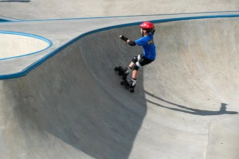 Young Inline Skater Riding Inside Concrete Skate Bowl Stock Photos