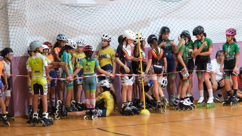 Young inline speed skaters wait behind the tape before the start of a children Stock Footage 312453822