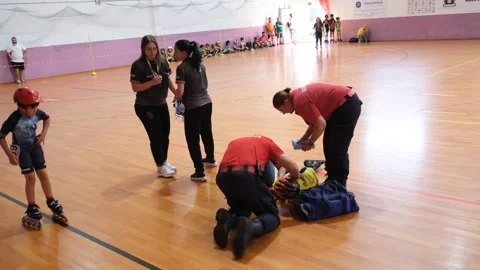 A young inline speed skating competitor lies on the ground after a fall during a Stock Footage 312453863