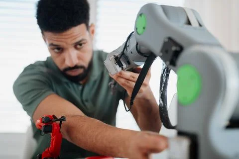 Young innovator developing robotic arm as part of home tech project. 스톡 사진