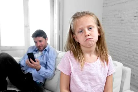 Young internet addict father using mobile phone ignoring his little sad daughter Stock-Fotos