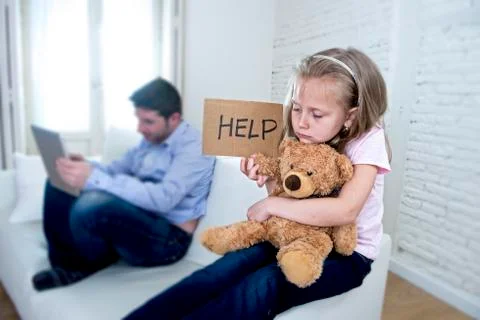 Young internet addict father using digital tablet  ignoring little sad daughter Stock Photos