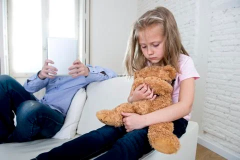 Young internet addict father using digital tablet  ignoring little sad daughter Stock Photos