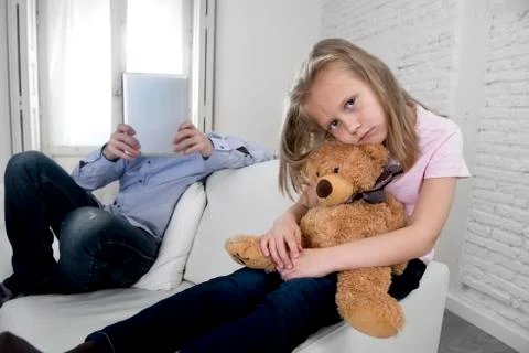 Young internet addict father using digital tablet  ignoring little sad daughter Stock-Fotos