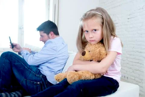 Young internet addict father using mobile phone ignoring little sad daughter Stock-Fotos