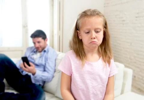 Young internet addict father using digital tablet  ignoring little sad daughter Stock Photos