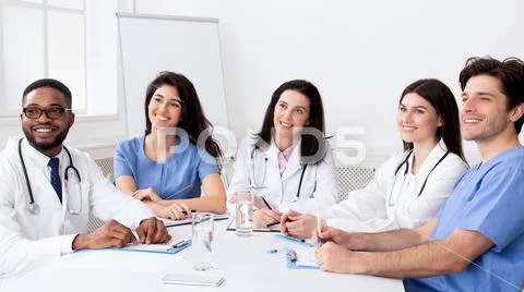Young interns listening to professor in conference room Stock Photos