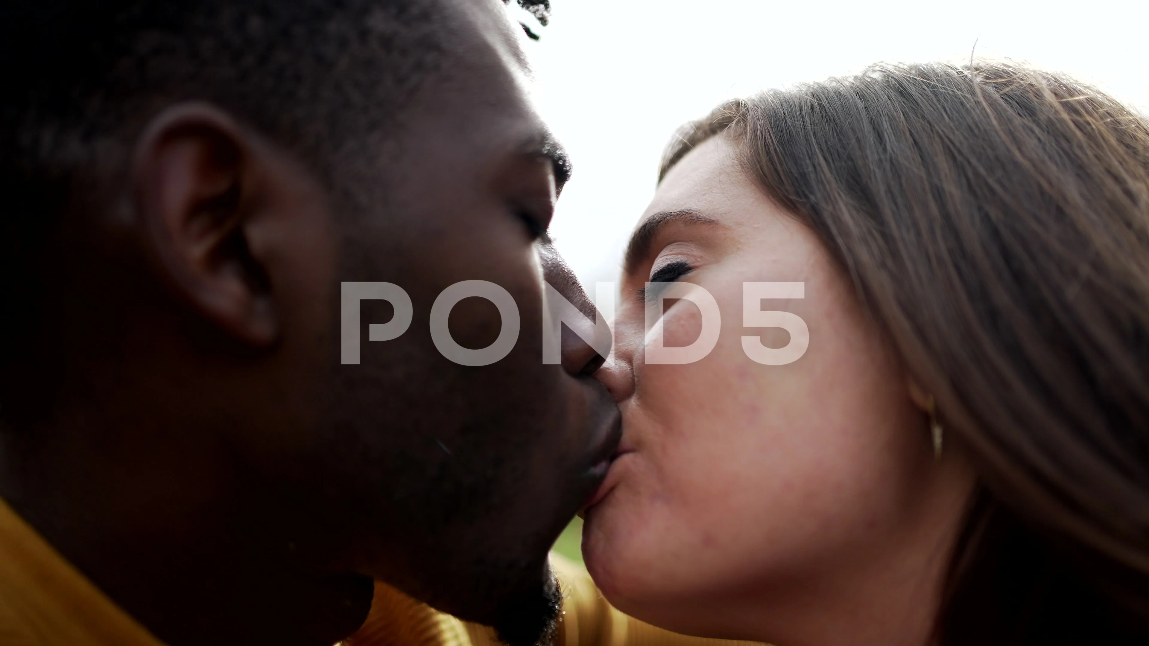 Young interracial couple kissing outside.. pic picture