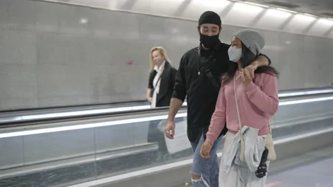 A young interracial couple of lovers in an underground subway corridor wearin Stock Footage 145228551