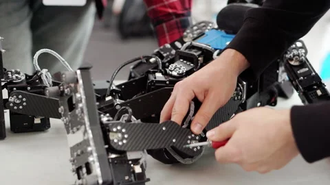 A young inventor engineer repairs his robot. Stock Footage 167669589