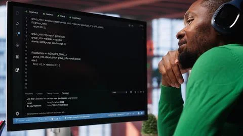 Young IT engineer typing code on computer and running script 스톡 사진