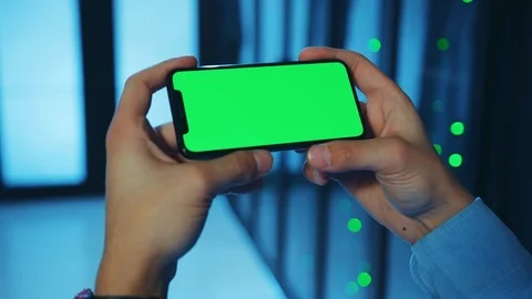 Young IT expert using smartphone greenscreen mock-up in horizontal position Stock Footage 121160595