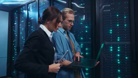 Young IT specialist making mistake on laptop showing to his female colleague Stock Footage 120796405