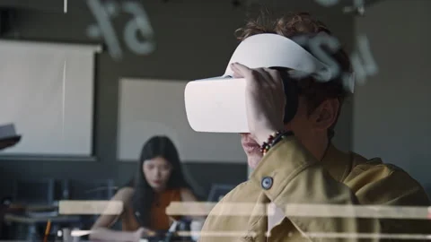 Young IT Specialist Using VR Headset with Remote Controller during Workday Stock Footage 275074814