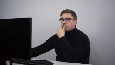 Young IT specialist works at the computer typing on the keyboard. A man with Stock Footage 231606651