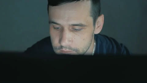 A young IT specialist works remotely on his laptop.Young attractive guy working Stock Footage 156869133