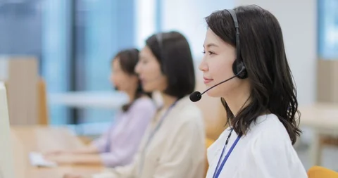 Young Japanese call center operator smiling at camera while working Stock Footage 127614117