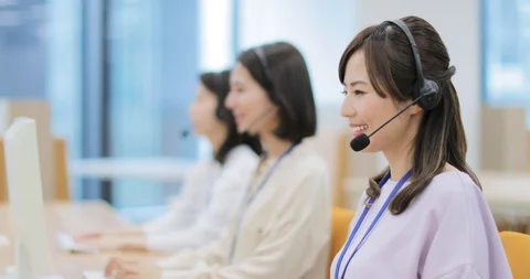 Young Japanese call center operator smiling at camera while working Stock Footage 127614123