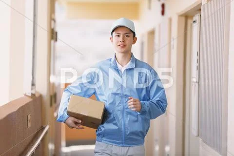 Young Japanese Delivery Man With Box
