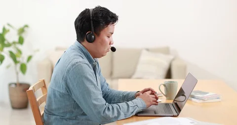 Young Japanese man working remotely from home Stock Footage 128406394