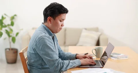 Young Japanese man working remotely from home Stock Footage 128406400