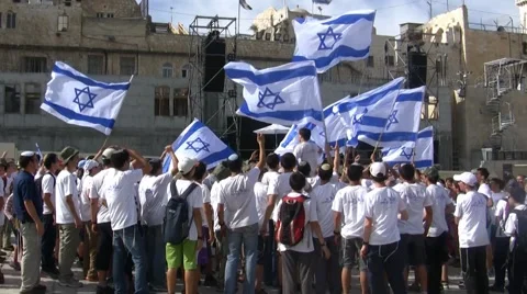 Young Jewish Yeshiva students dance with flags Western Wall, Jerusalem Israel Stock Footage