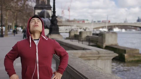 Young jogger stops to catch his breath before running off again Video stock 85592342