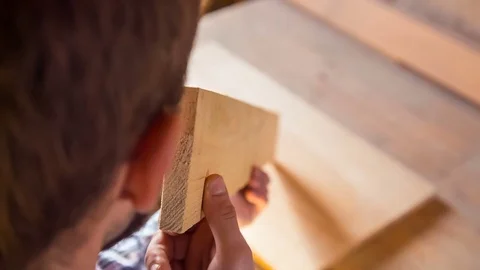 The young joiner inspects the timber equality Stock Footage 84449138