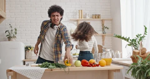 Young joyful couple spending time together cooking. Asian people dancing and Stock-Footage 132688778