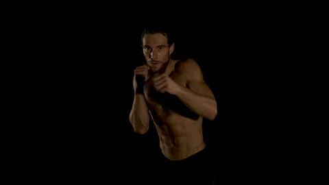 Young kickboxer shadow boxing in the darkness. Video stock 85852484