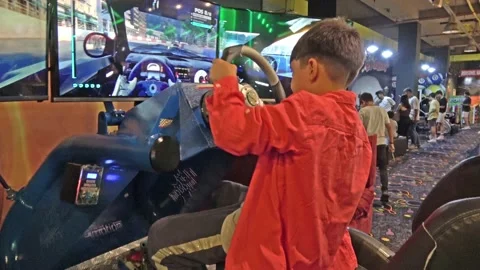 Young kid can hardly cope with racing machine simulator Vídeos de archivo 197481314