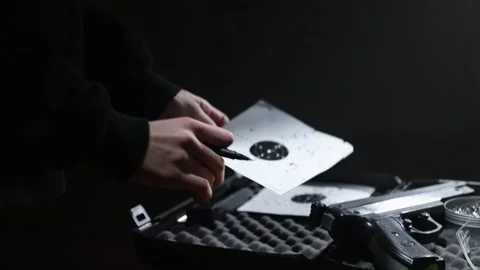 Young kid is checking paper shooting targets after shooting with air pistol. Video stock 171704411