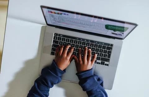 Young kid coding on a laptop in a computer science class 写真素材