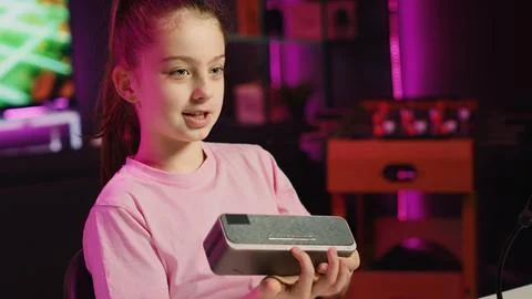 Young kid entertainer doing technology review of Bluetooth portable speaker Stock-Fotos
