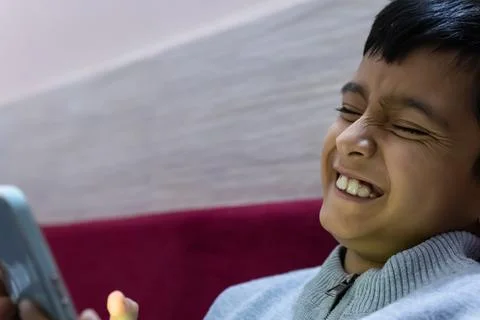 Young kid facial expression while watching mobile and playing online game a.. Stockfoto's