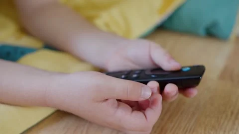 Young kid interacts with remote, small child playing with television remote 스톡 동영상 321212034