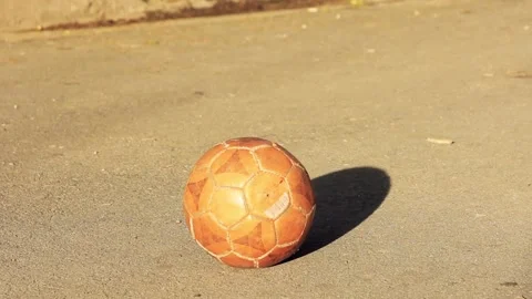 Young Kid kicking Soccer Ball in the City Street. Close Up. Low Angle View. Stock Footage