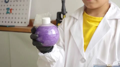 Young kid in lab costume doing scientific experiment Stock Footage 280684891