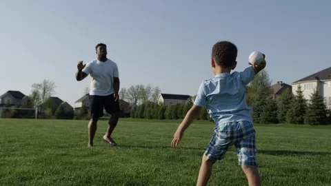 Young kid playing catch with his father outside summer Stock Footage 89927638