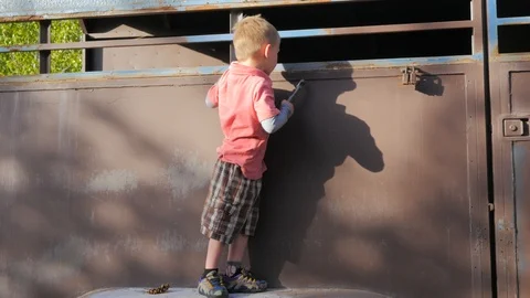 Young kid pretending to work on a trailer with pliers Stock Footage 92583732