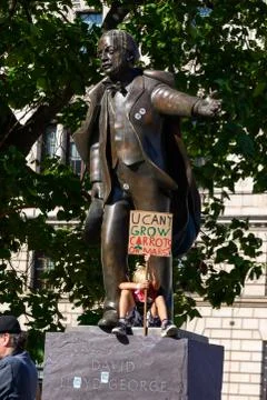 Young kid protesting Climate Change while sitting on a statue in Parliament S Stock Photos