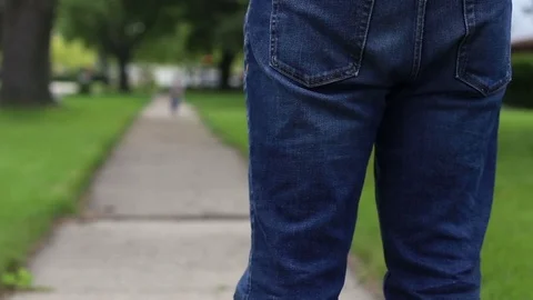 Young kid running back to parent on sidewalk, video Video stock 78534593