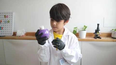 Young kid in scientific costume studying chemistry Stock Footage 280684876
