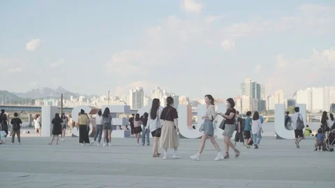 Young Korean adults at Han River taking pictures on statue Stock Footage 115520577