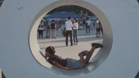 Young Korean boy at Han River playing inside statue Stock Footage 114852734