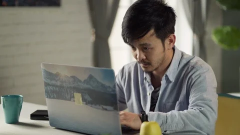Young Korean man tired working on laptop at home Stock Footage