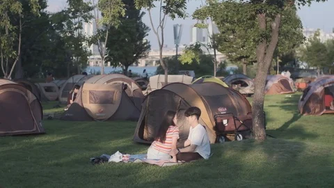 Young Koreans camping at Han River for weekend fun and flirting Stock Footage 114854141