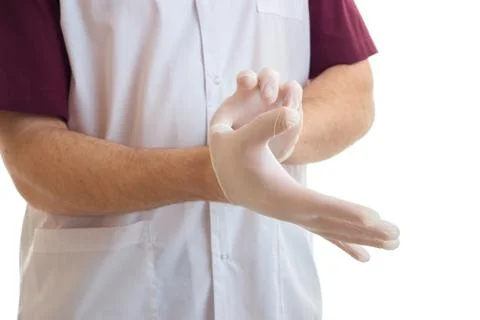 A young Laboratory Assistant puts on hand white medical gloves close-up Stock Photos