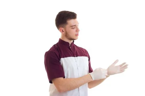 A young Laboratory Assistant puts hands on white gloves close-up Stock Photos