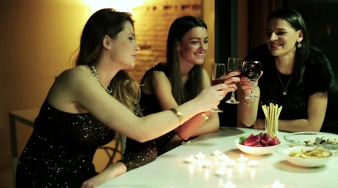 Young ladies drinking wine by the table Stock Footage